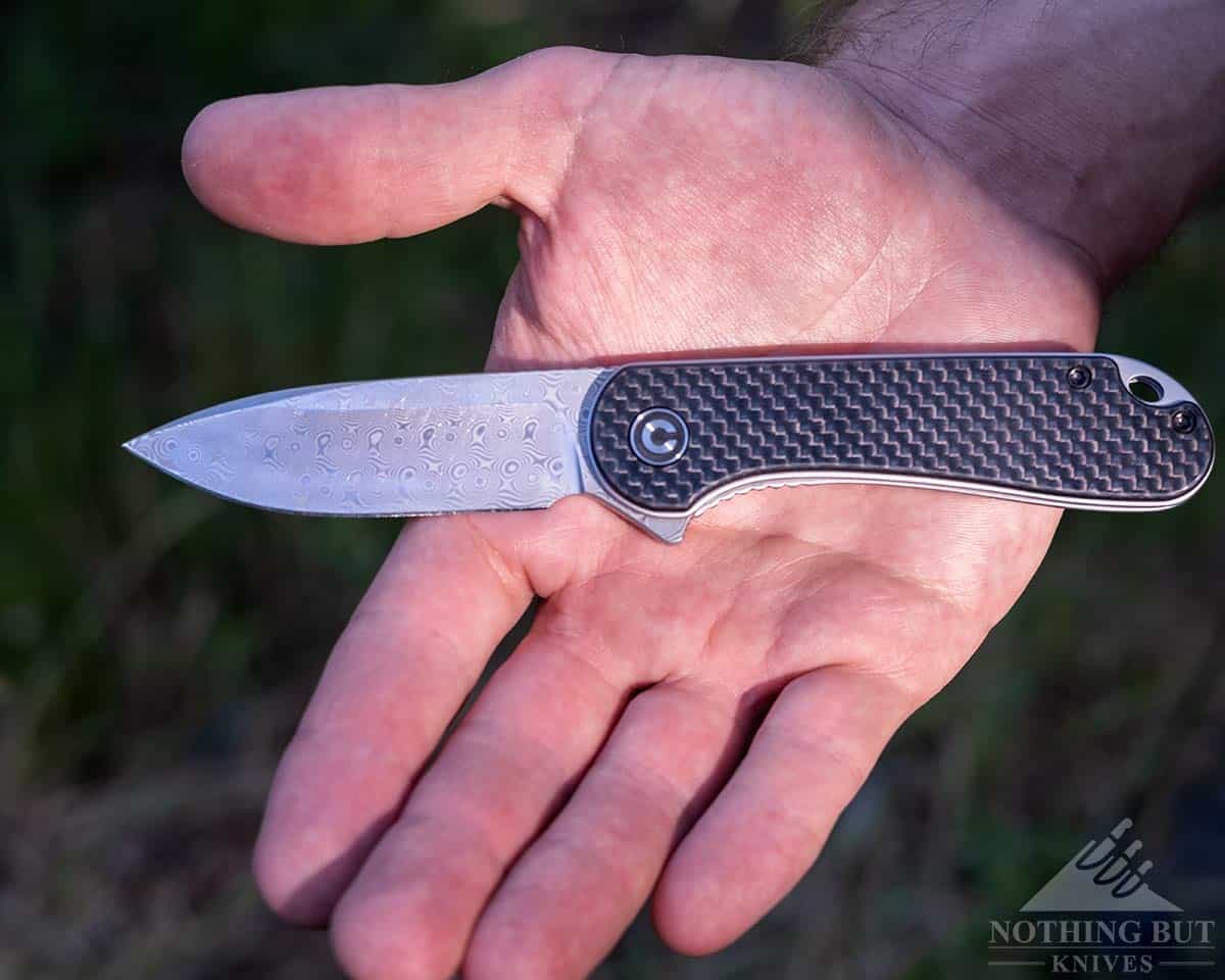 The Elementum folding knife in the palm of a man's hand. 
