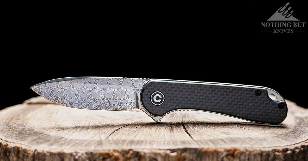 Header image for our in depth review of the Civivi Elementum Damascus knife review showing the knife on a tree stump..
