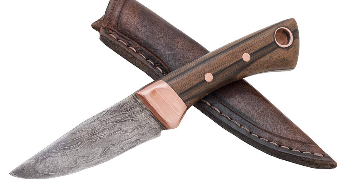 Damascus steel knife with a leather sheath on a white background. 