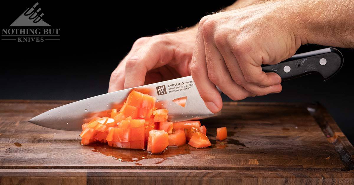 The Zwilling Professional S 8 inch chef knife blade chopping tomatoes. 