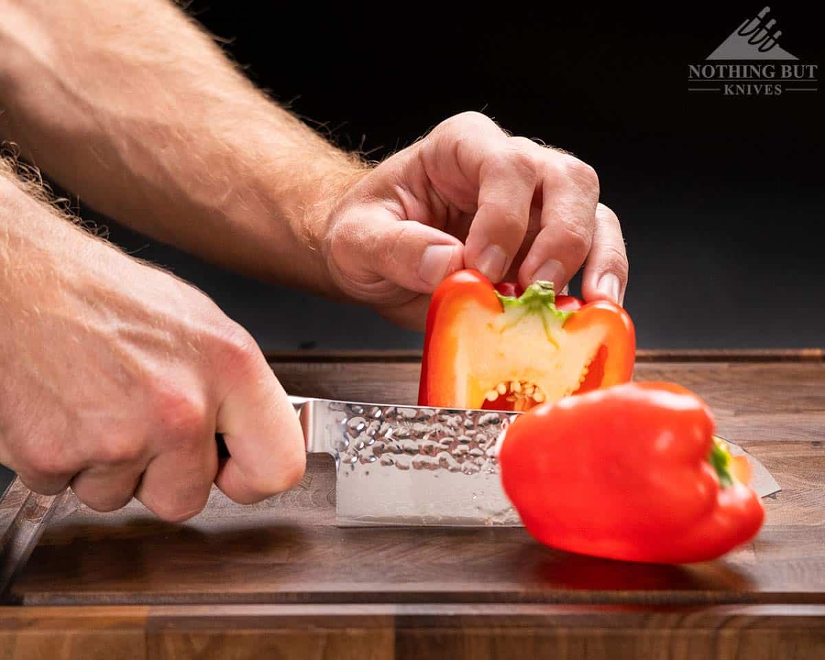 A close-up of the Enso Santoku HD kitchen knife slicing through a red bell pepper. 
