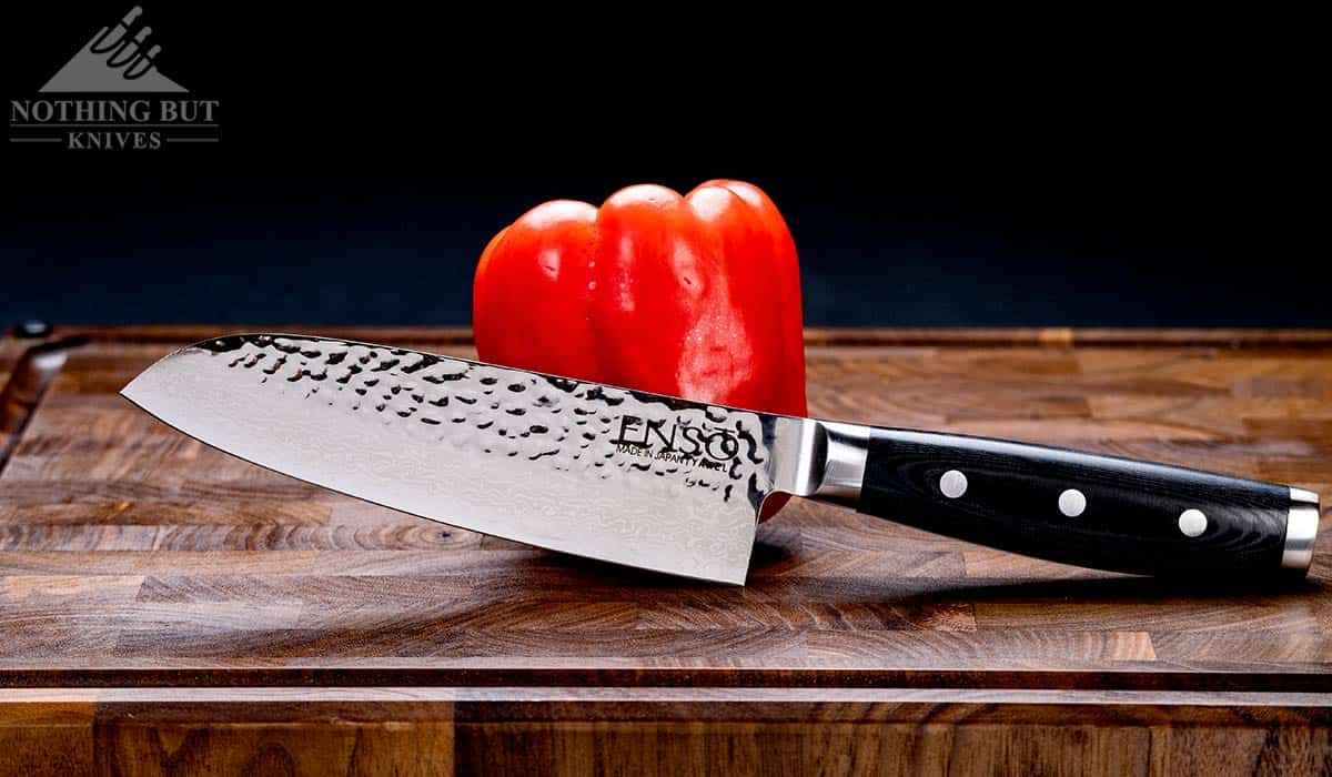 Header image for an in-depth, hands on review of the Enso HD Santoku knife showing the knife on a cutting board next to a red bell pepper.
