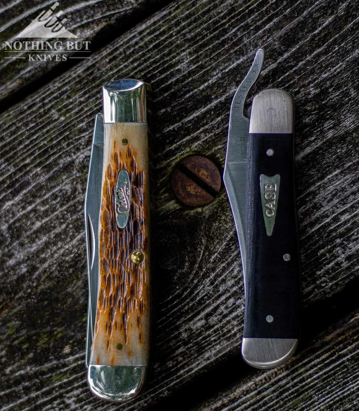 The Case Russlock next to the bone handles Trapper on weathered wood. 