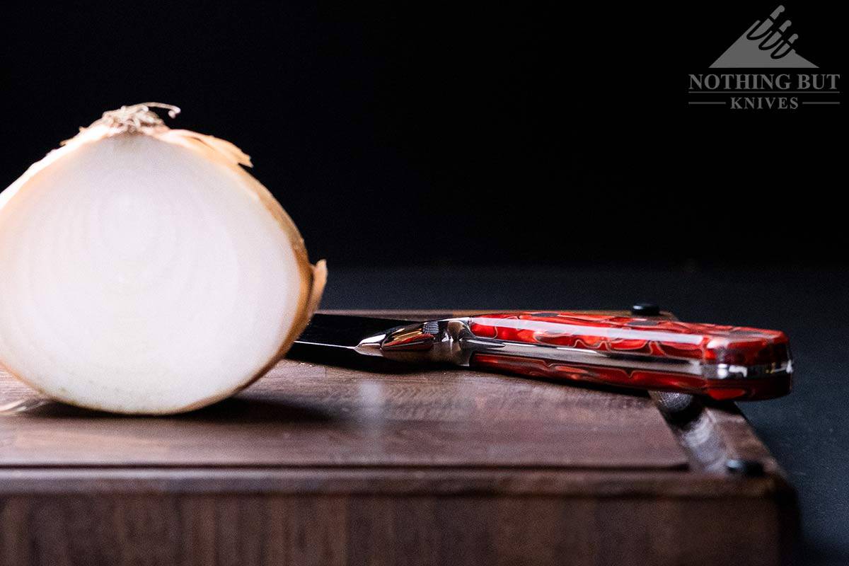 Handle of the Lamson 8 inch chef knife next to a sliced onion. 