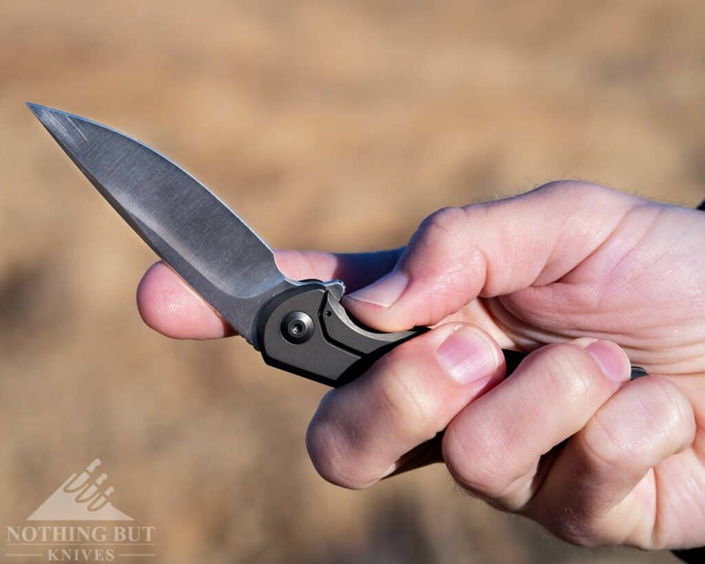 A person's hand pushing open the frame lock on the Nox to close the blade. 