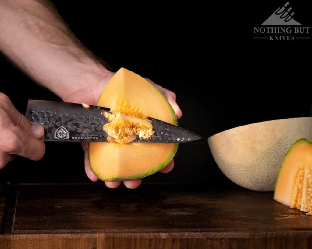 A close-up of the Dalstrong Shogun X chef knife cutting the core from a melon.