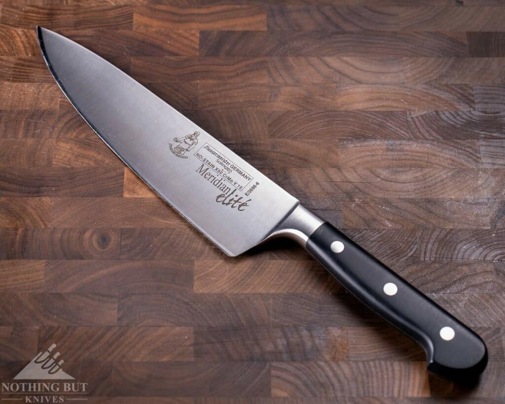 The Messermeister Meridian Elite Chef Knife is a similarly priced alternative to the Shogun 8 inch chef knife. the Messermeister is pictured here on a wood cutting board.