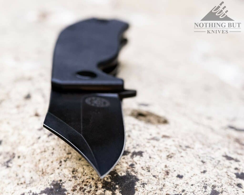Off-Grid Knives Caiman Review - Image 2 The blade of the Caiman is tough and toothy. It is pictured here on a granite rock in a creek.