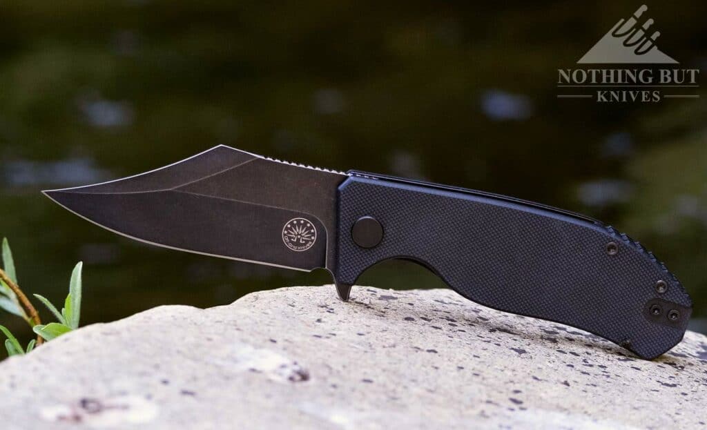 The Off-Grid Caiman is a unique folder with a Bowie style blade. It is shown here on a Granite rock in a mountain creek. 