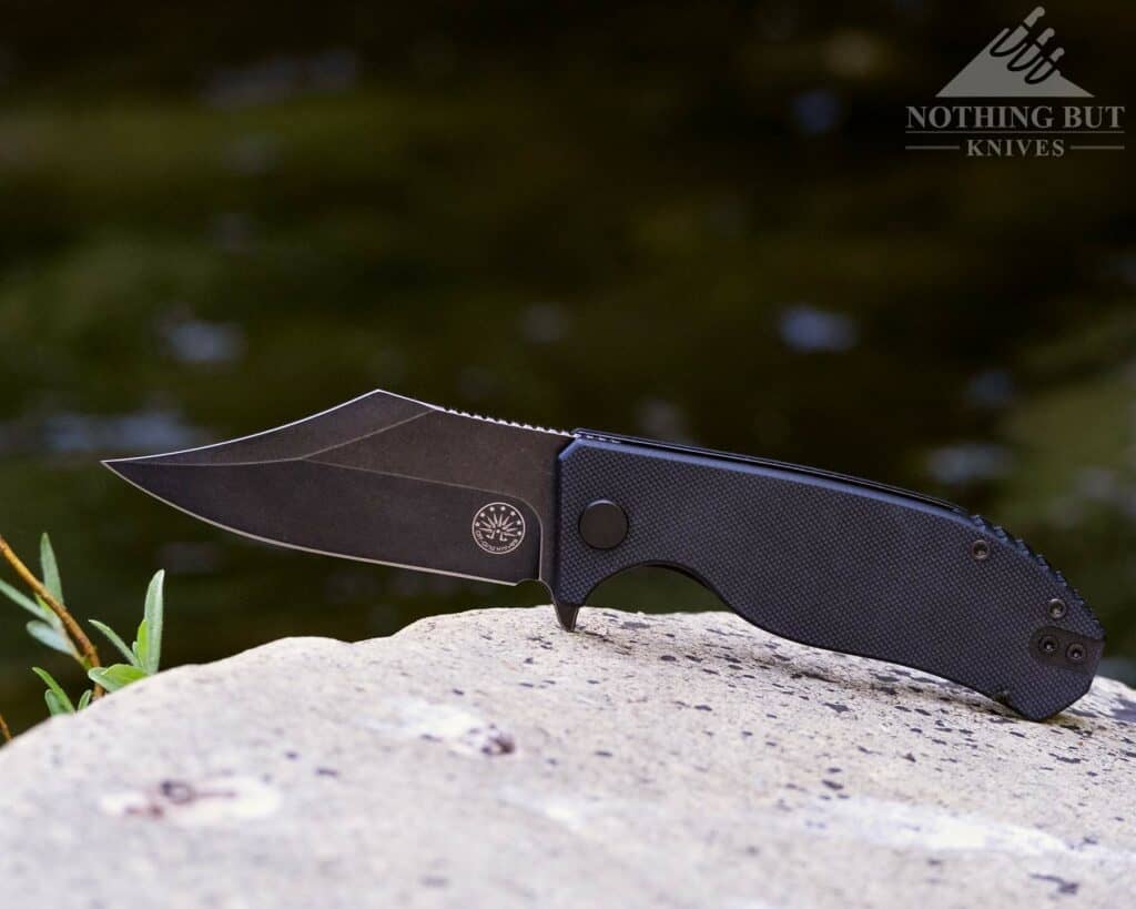 We reviewed the Off-Grid Caiman Bowie style folding knife. It is pictured here on a granite rock in a mountain creek.