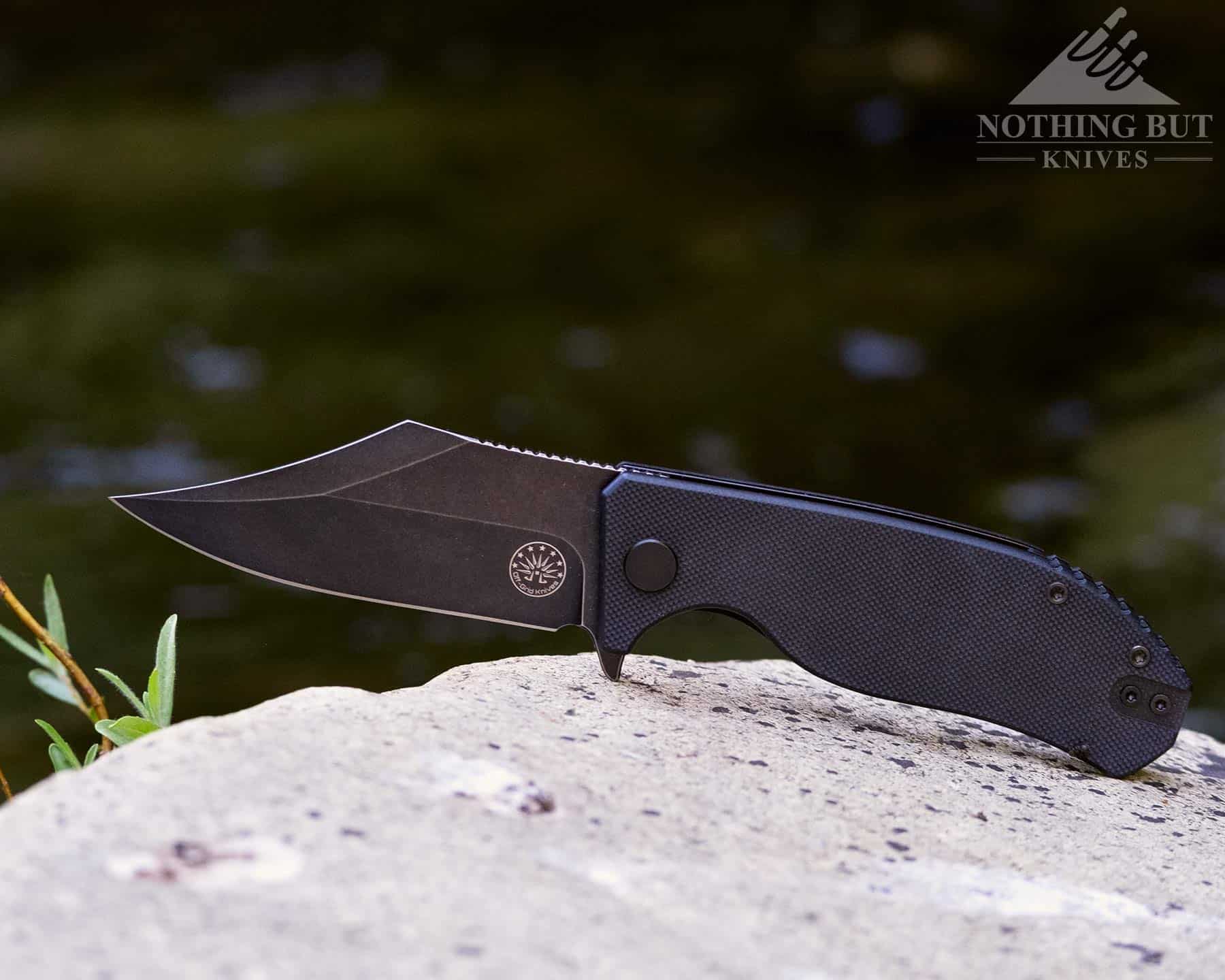 Boker Plus Hea Hunter Review - Image 18 We reviewed the Off-Grid Caiman Bowie style folding knife. It is pictured here on a granite rock in a mountain creek.