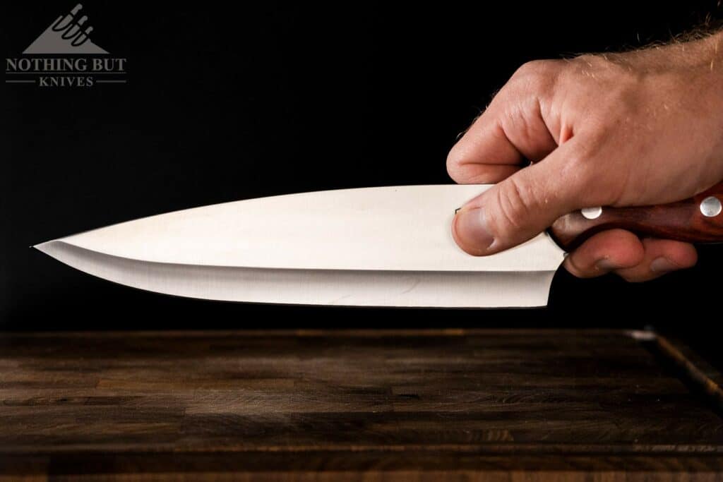 A person's hand folding the Buck 931 chef knife in a pinch grip. 