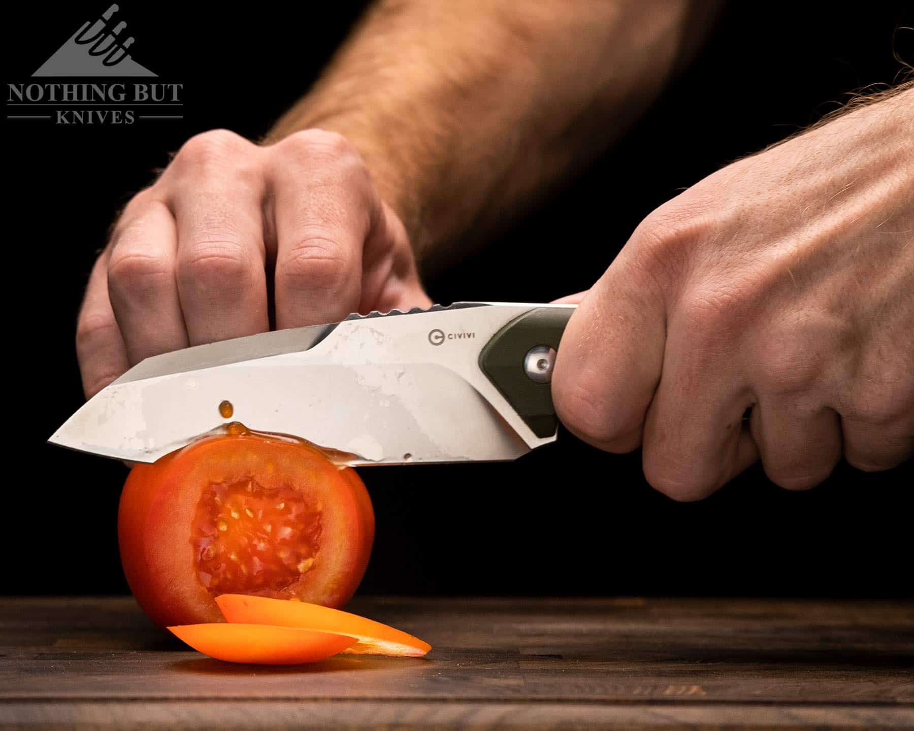 The Civivi Kepler slicing through a tomato on an end grain cutting board. 