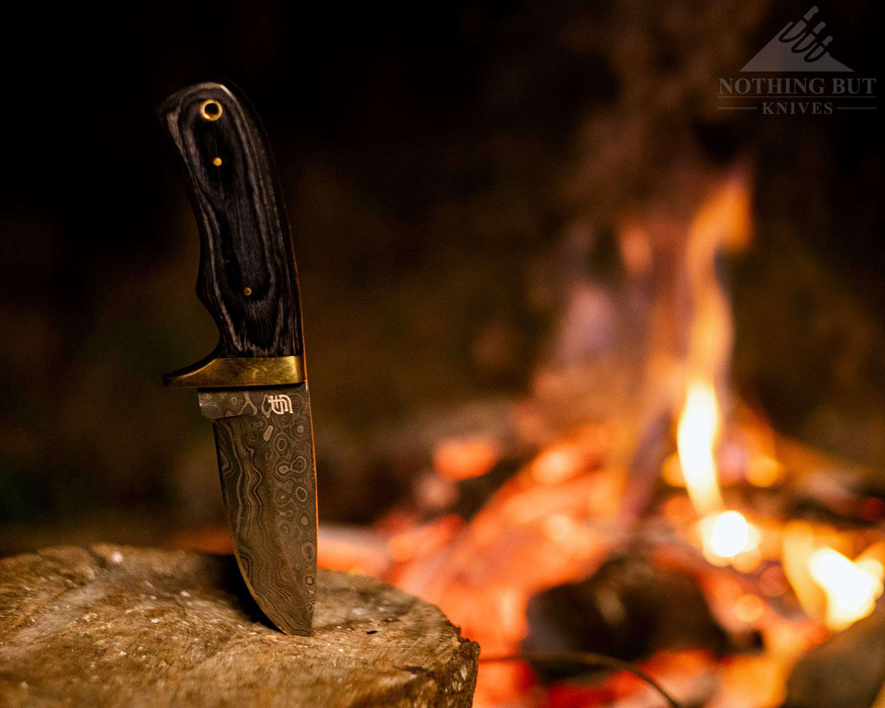 The Forseti Steel Jim Baker Damascus hunting knife knife next to a campfire after a day of testing for this knife review. 