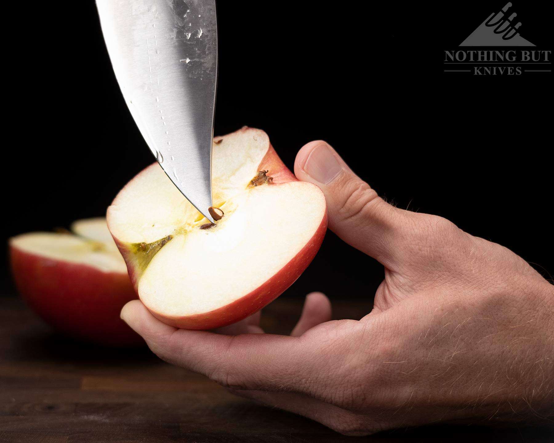 A close-up of the blade tip removing seeds from an apple. 