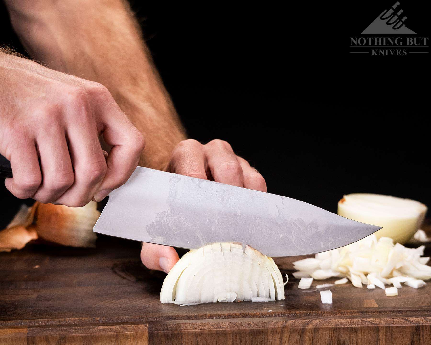 Mattia Borrani Bowie Chef Knife Review - Image 2 A close-up of the Mattia Borrani chef knife chopping an onion.
