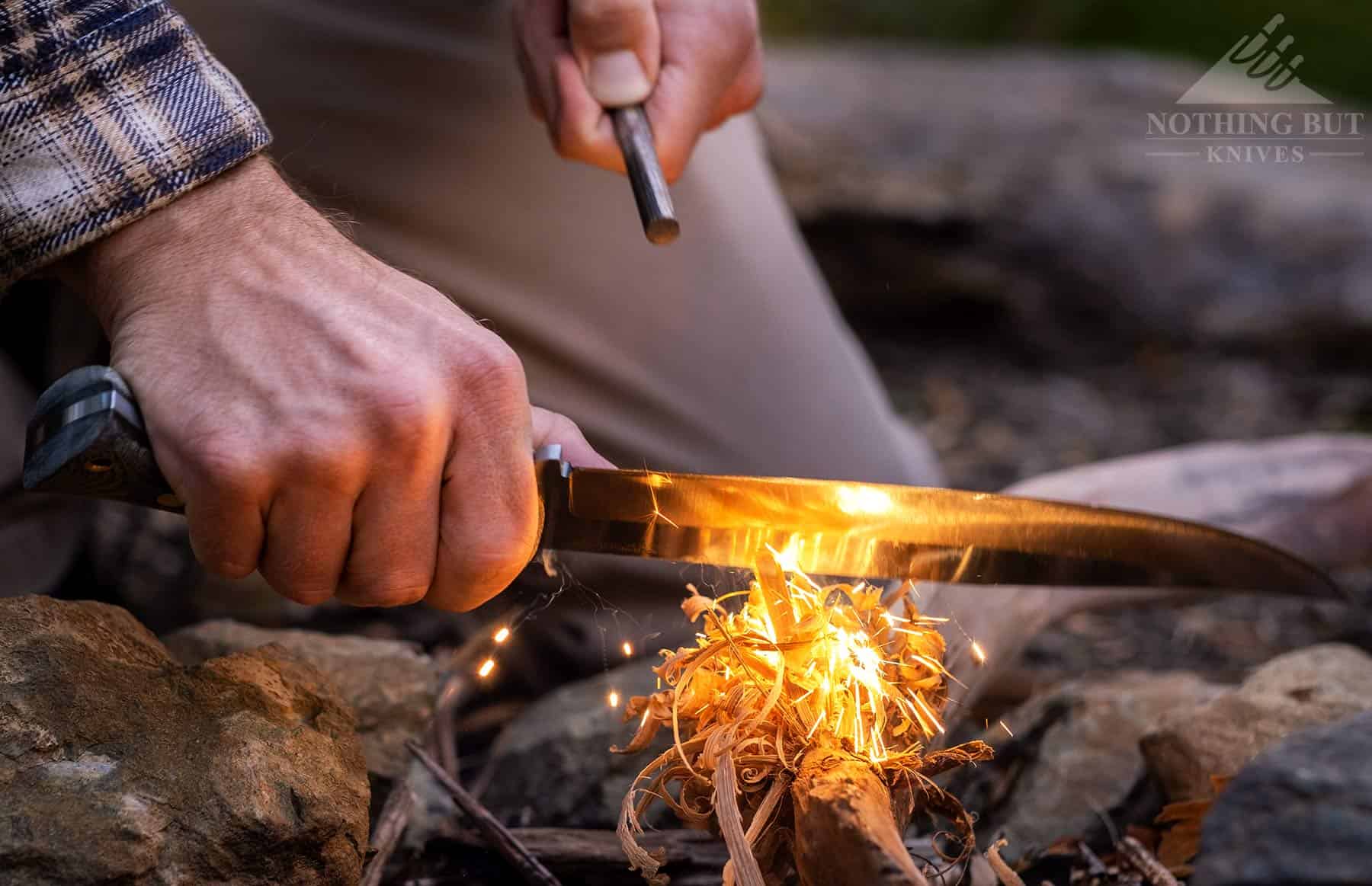 The Condor Plan A Bowie sparking a ferro rod to start a fire. This image shows this knife's fire making capabilities. 