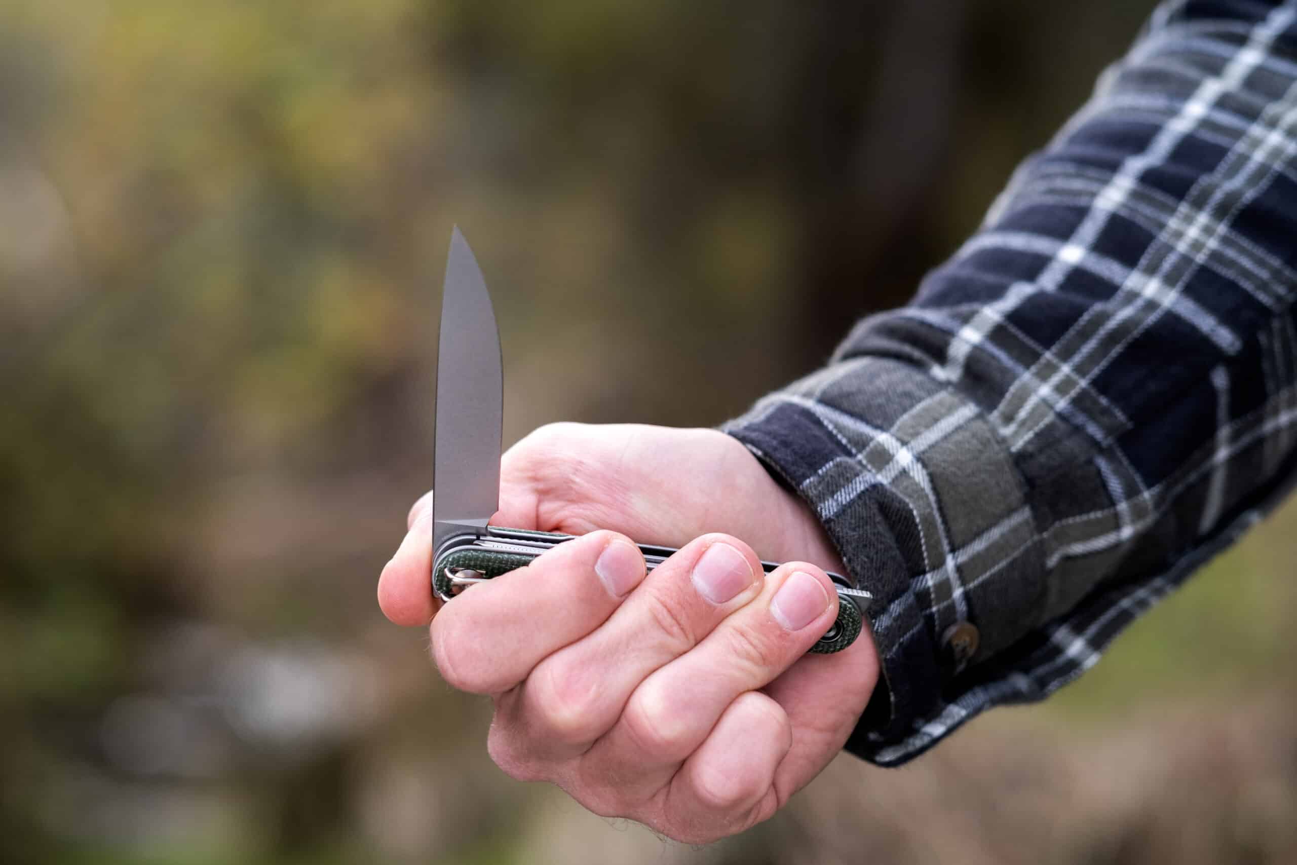 A person's hand opening the knife blade of the Civivi Crit with the front flipper tab. 