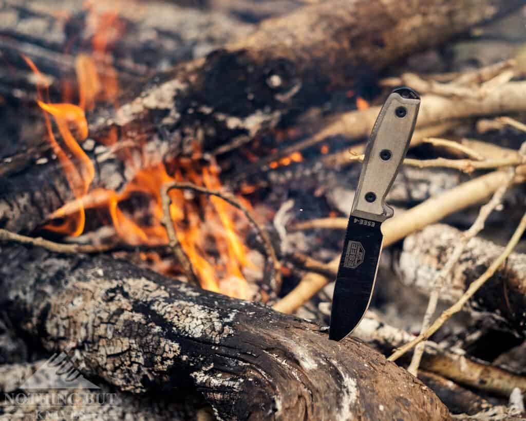 An Esee 4 knife next to campfire.