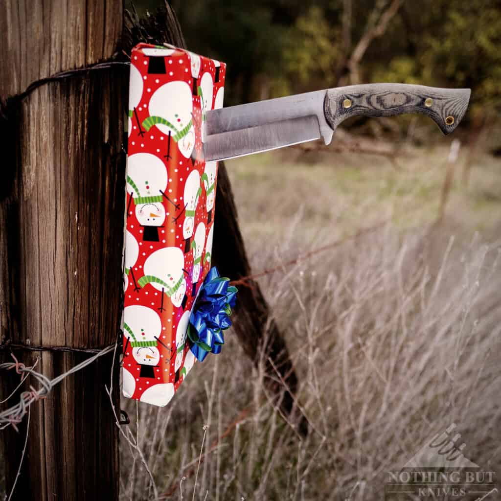 The Condor Plan A Bowie stabbed through a Christmas gift and into a fence post.