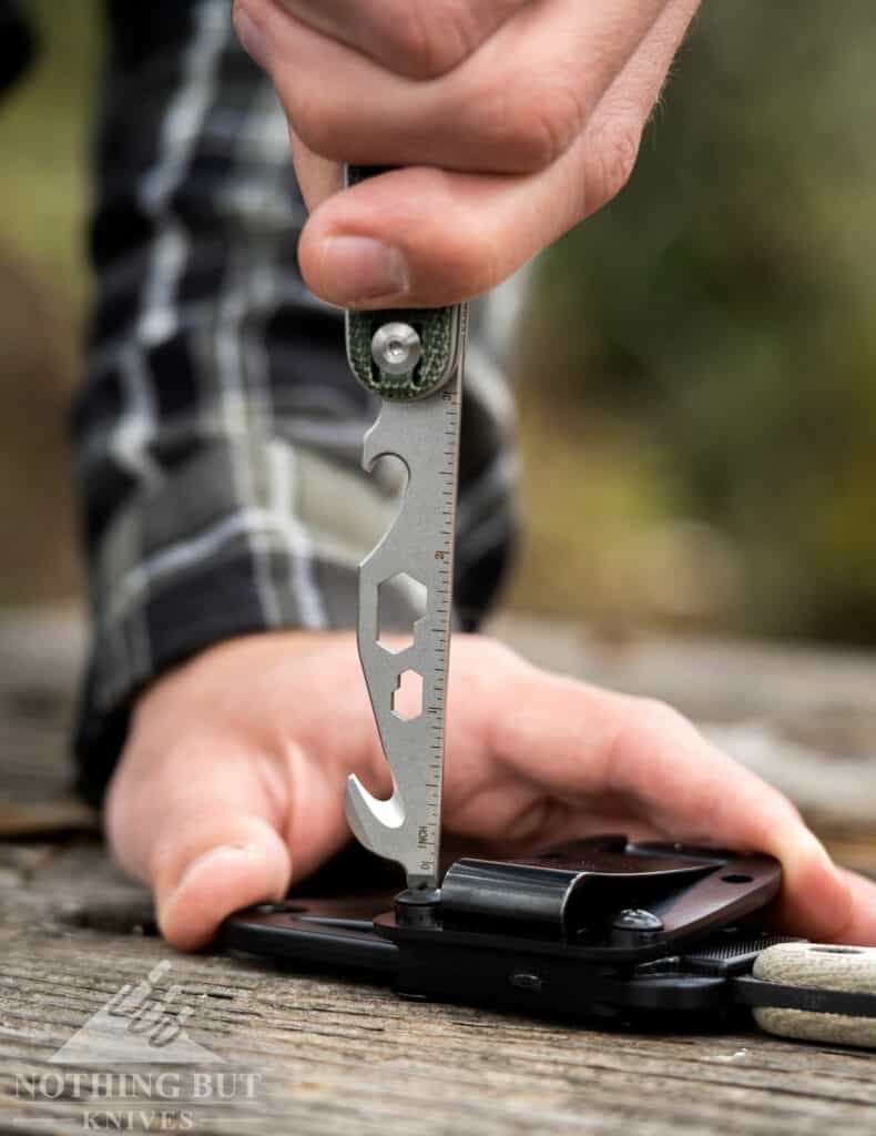 A close-up of the Civivi Crit toolbar being used to tight screws on a knife sheath. 