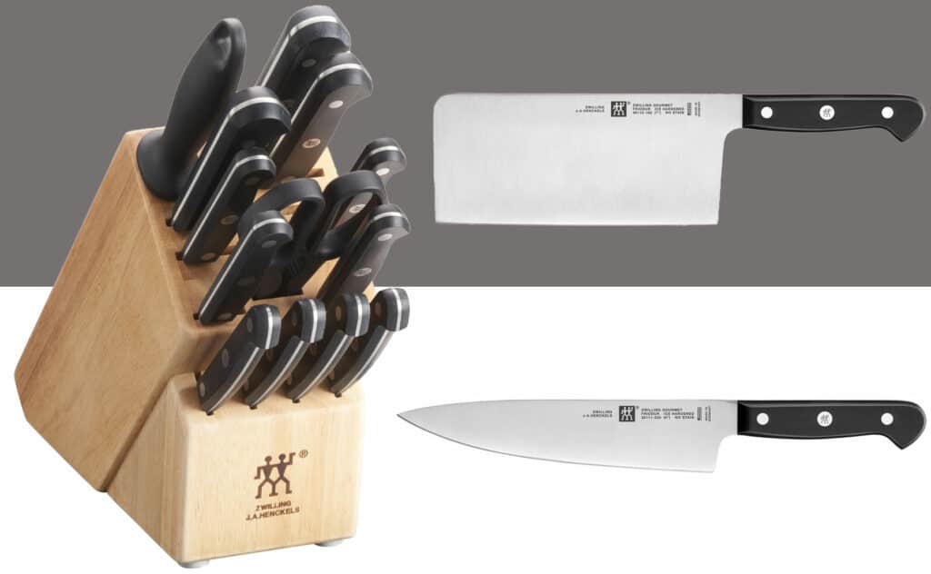 A Zwilling Gourmet 14 piece knife set together with an eight inch chef knife and a seven inch cleaver shown outside the storage block. 