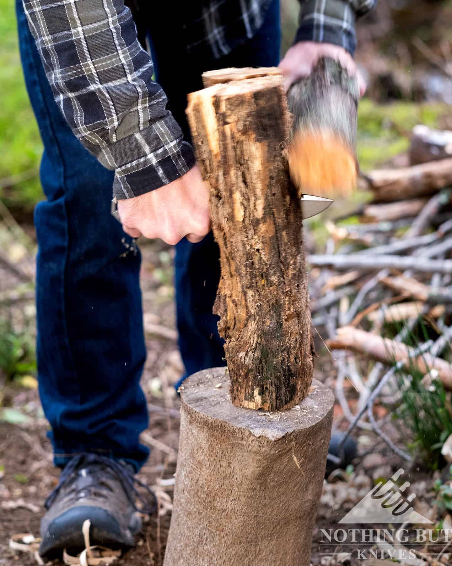 A close-up of the Woox 62 survival knife being used to baton a piece of wood. 