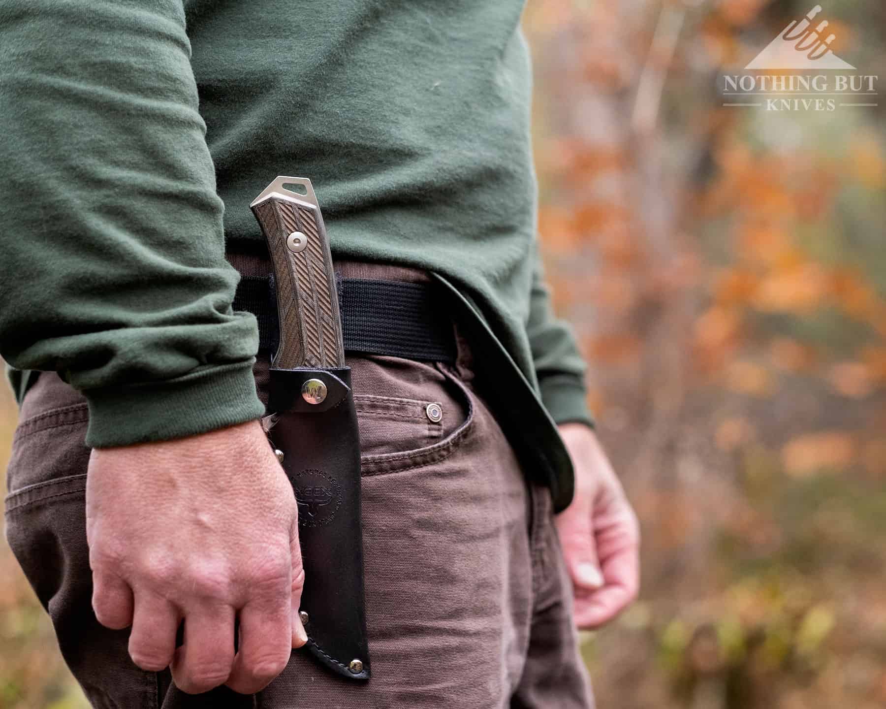 The Woox Rock 62 in a sheath on a person's belt to show scale and the ideal carry position. 