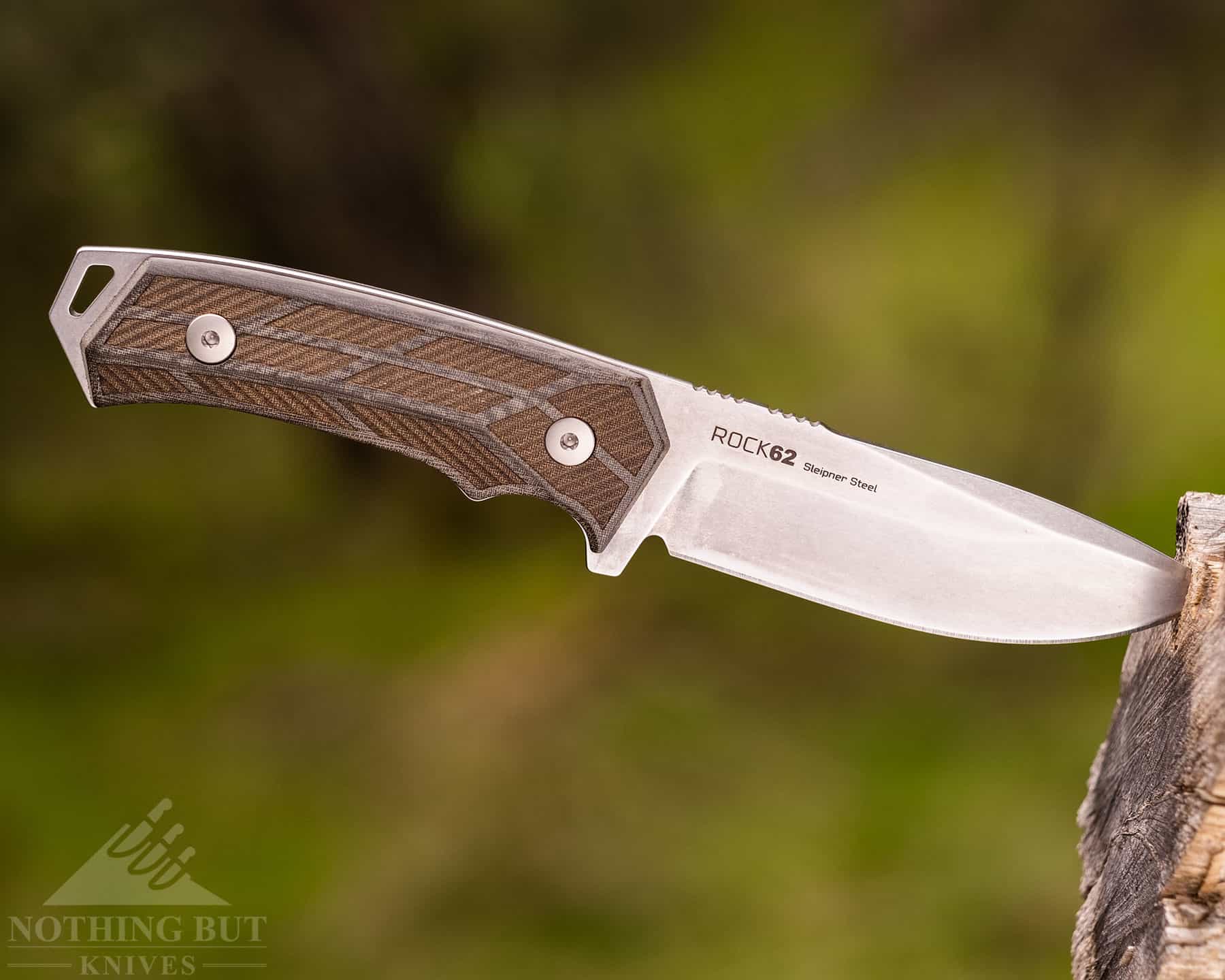 The Woox 62 is manufactured in both Italy and America. The result is a very capable outdoor fixed blade. It is shown here sticking out of a branch in the woods. 