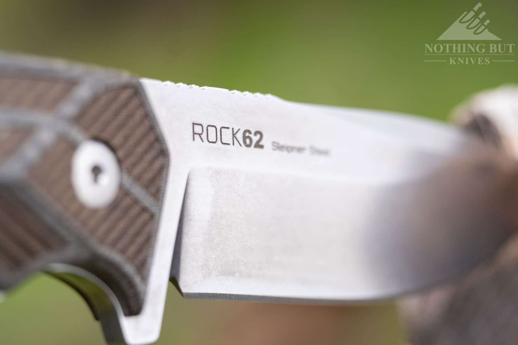 A macro image showing the Rock 62 logo and steel type printed on the blade. 