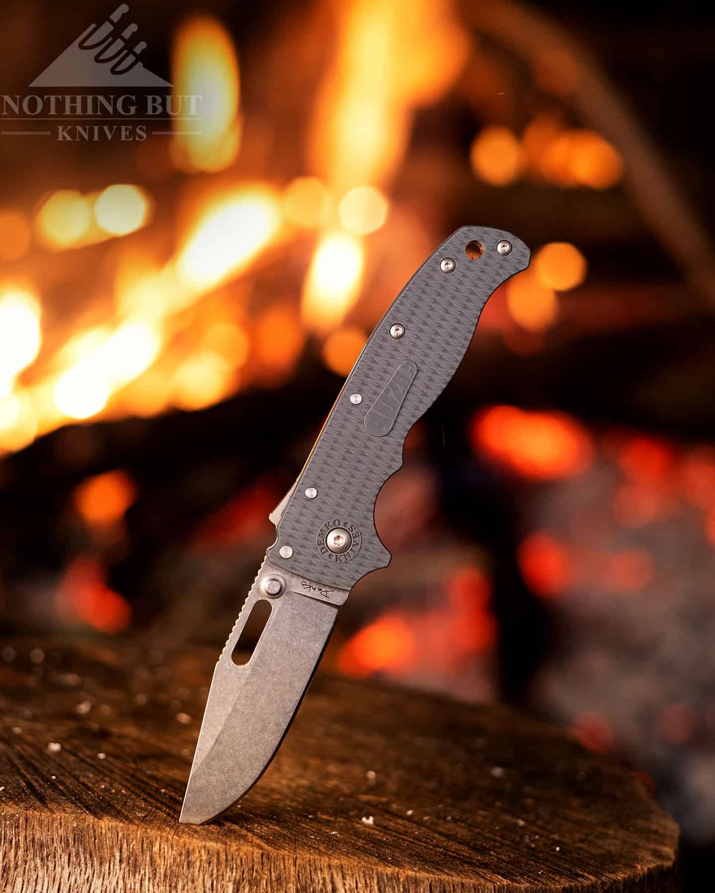 Sog Vision Xr Review - Image 14 The Demko 20. sticking out of a stump next to a campfire.