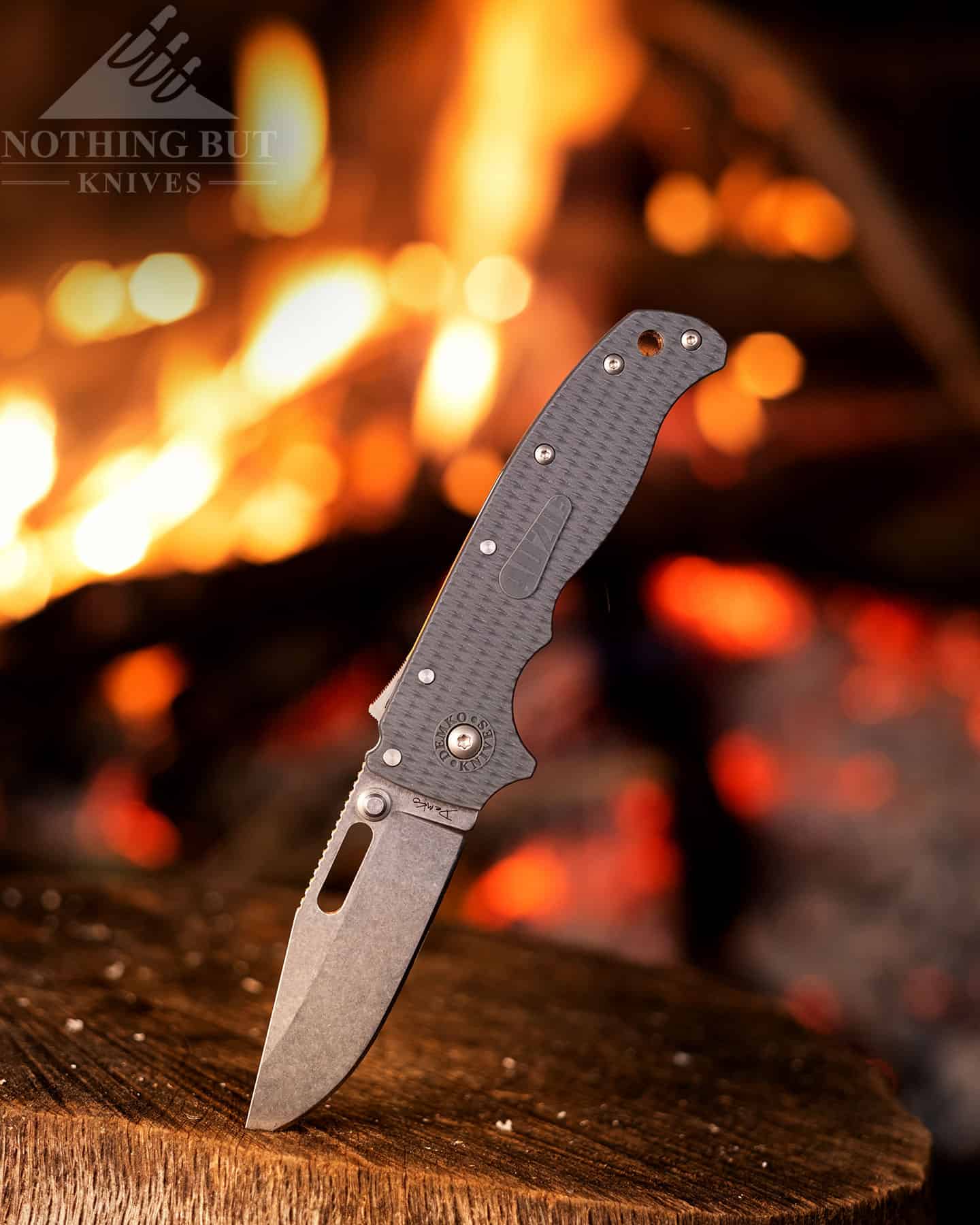 The Demko 20. sticking out of a stump next to a campfire.