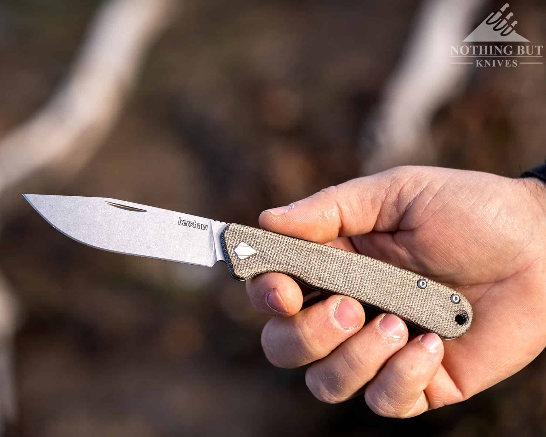 A close-up of the Federalist handle in a person's hand that shows the texture of the dry Micarta. 