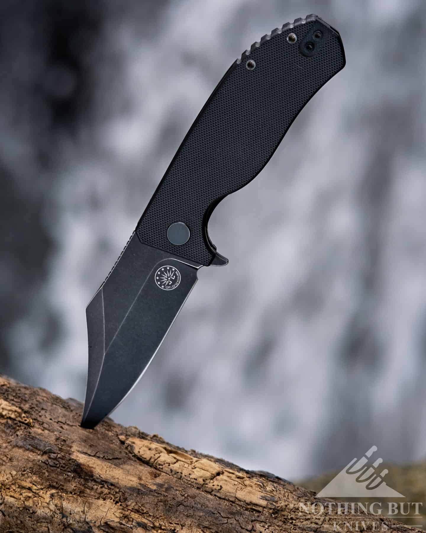The Off-Grid Caiman with a D2 steel blade in the open position in front of a waterfall.