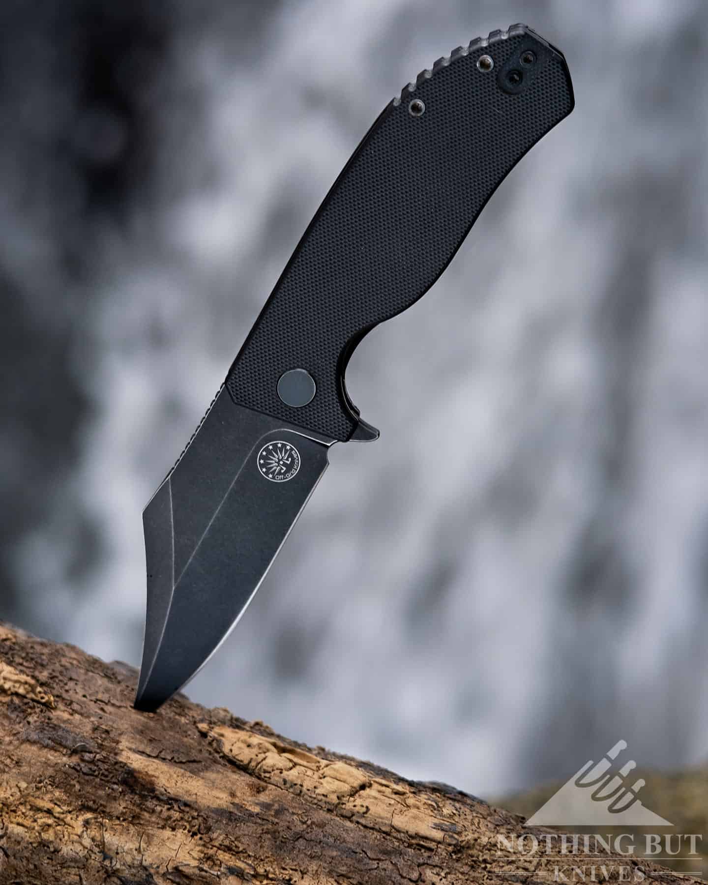The Best D2 Steel Knives And What Makes Them Great - Image 7 The Off-Grid Caiman with a D2 steel blade in the open position in front of a waterfall.