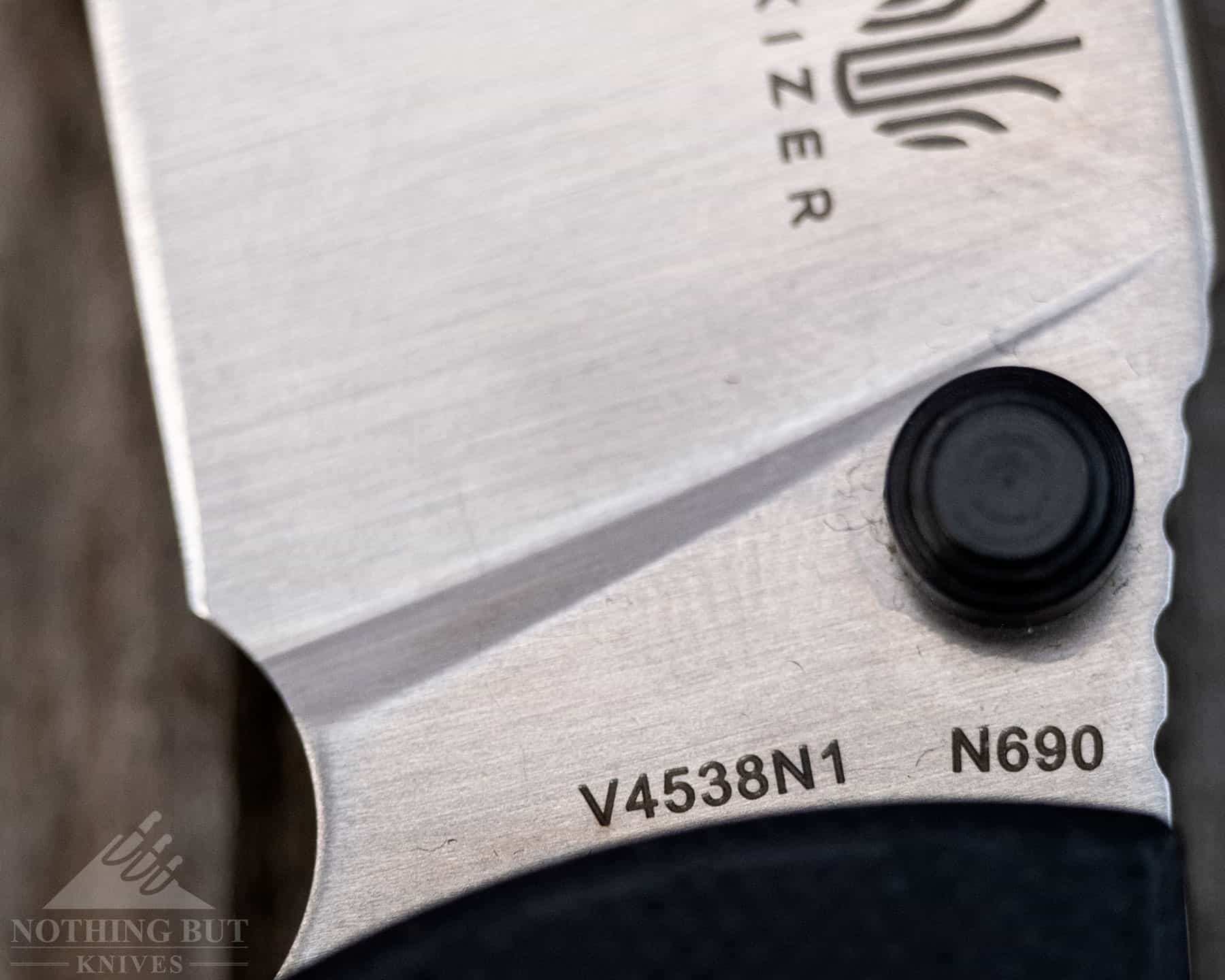 A macro image of the branding on the Kizer Slicer blade including the Bohler N690 steel text.