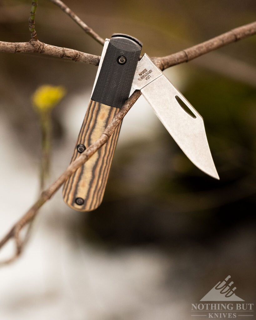 Best Slip Joint Knives For Nostalgic Edc - Image 40 The Case Crossroads Barlow slip joint knife shown here in the half open position hanging from a tree branch above a creek.