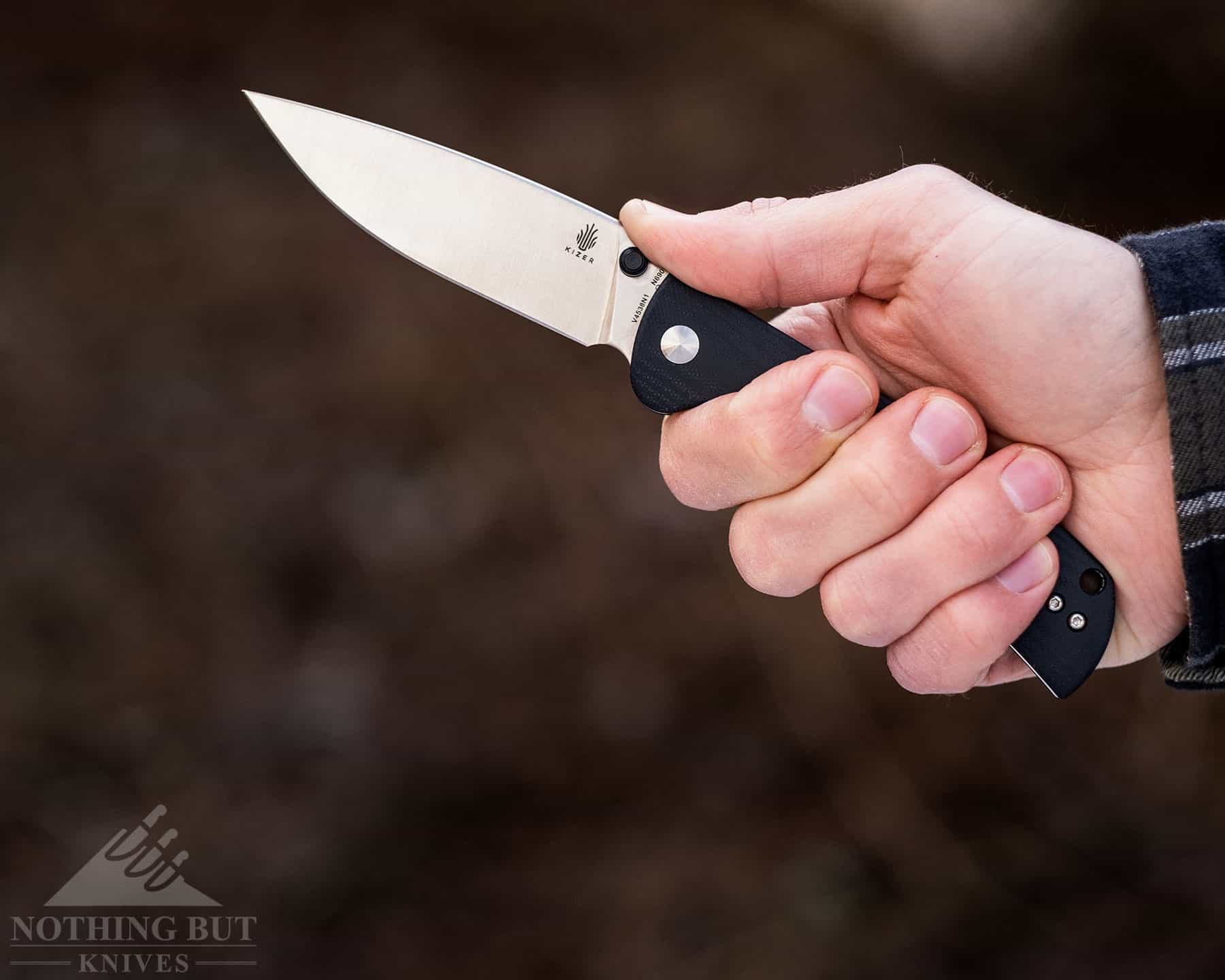 The Kizer Slicer lockback knife in a person's hand to show the size of the knife and the handle ergonomics. 