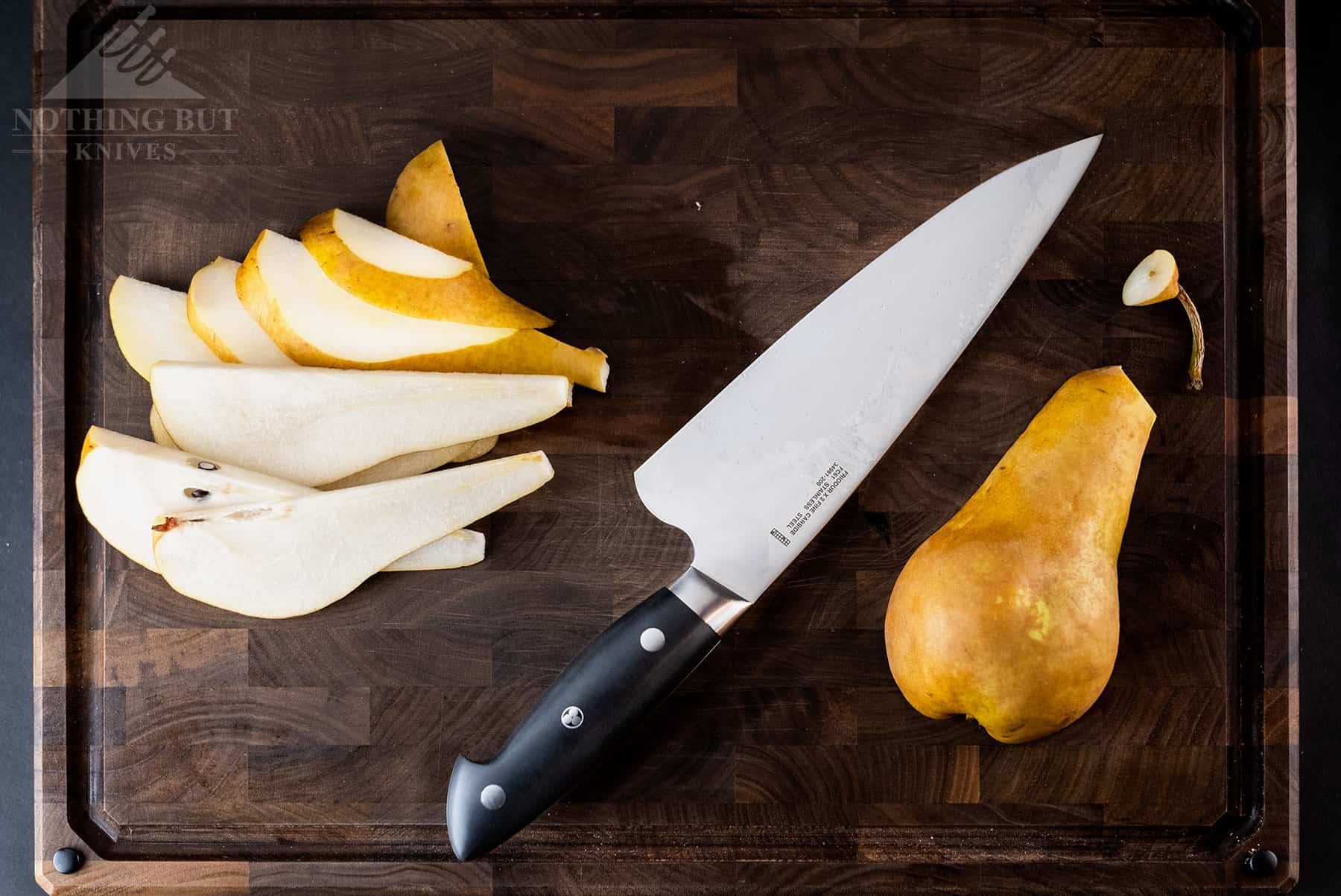 The Zwilling by Kramer Euroline 8 inch chef knife is the standout knife in this set. It is pictured hear on a cutting boars with a pear it sliced into pieces.