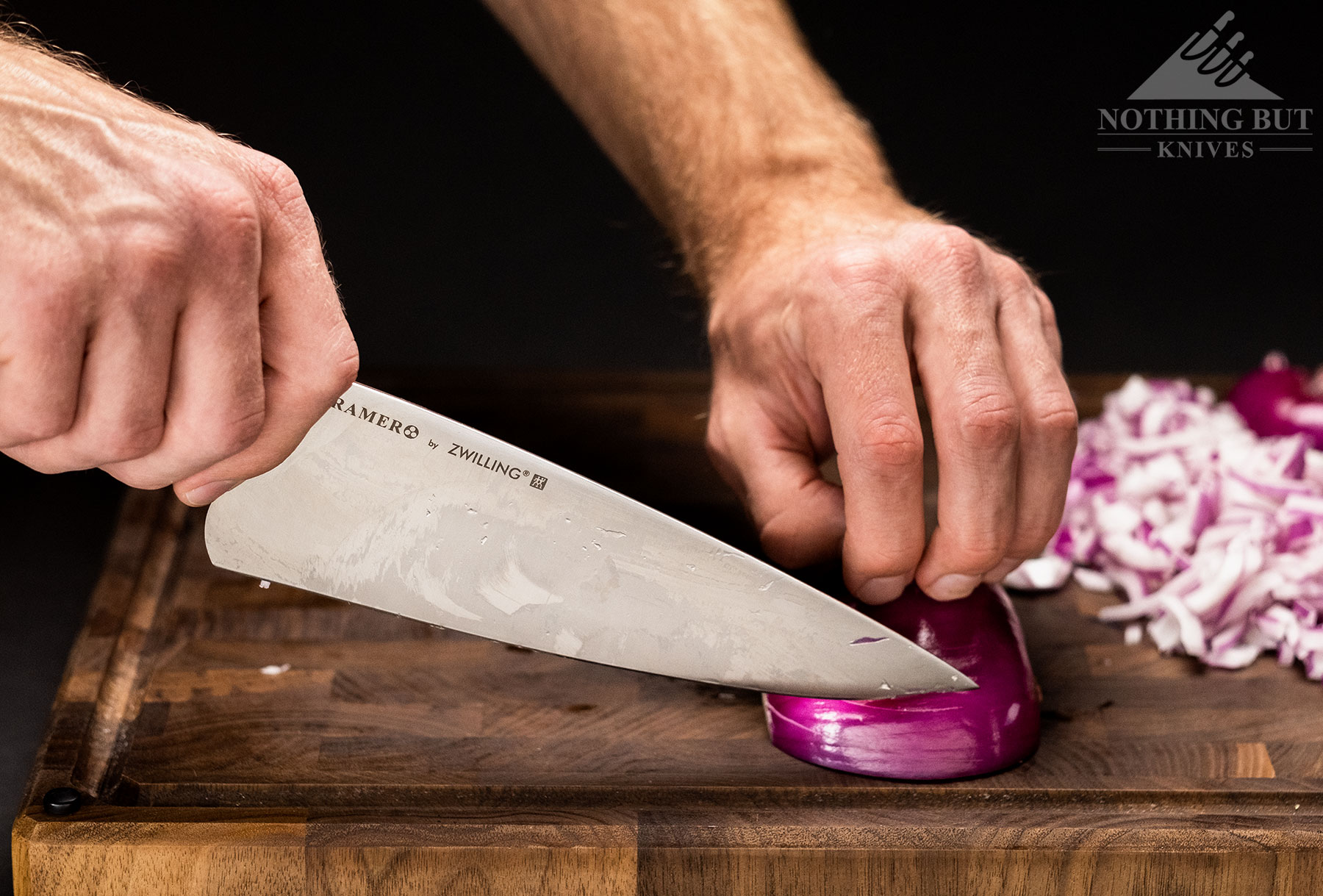 Kramer By Zwilling Essential Collection Chef Knife Review - Image 5 Making small cuts in a red onion with the Bob Kramer designed Zwilling chef knife.