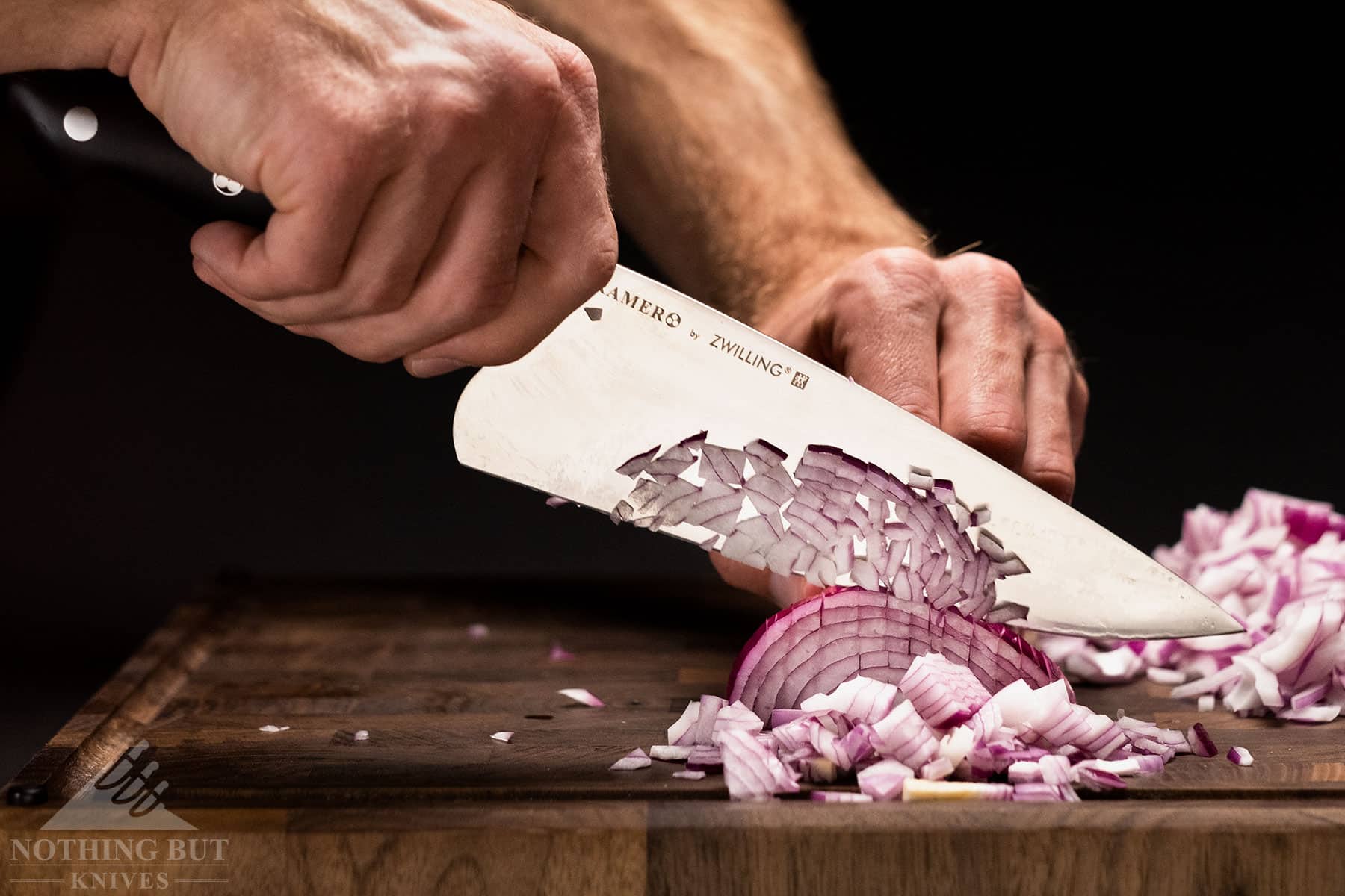 Diced onions sticking to the blade of a Kramer By Zwilling chef knife.