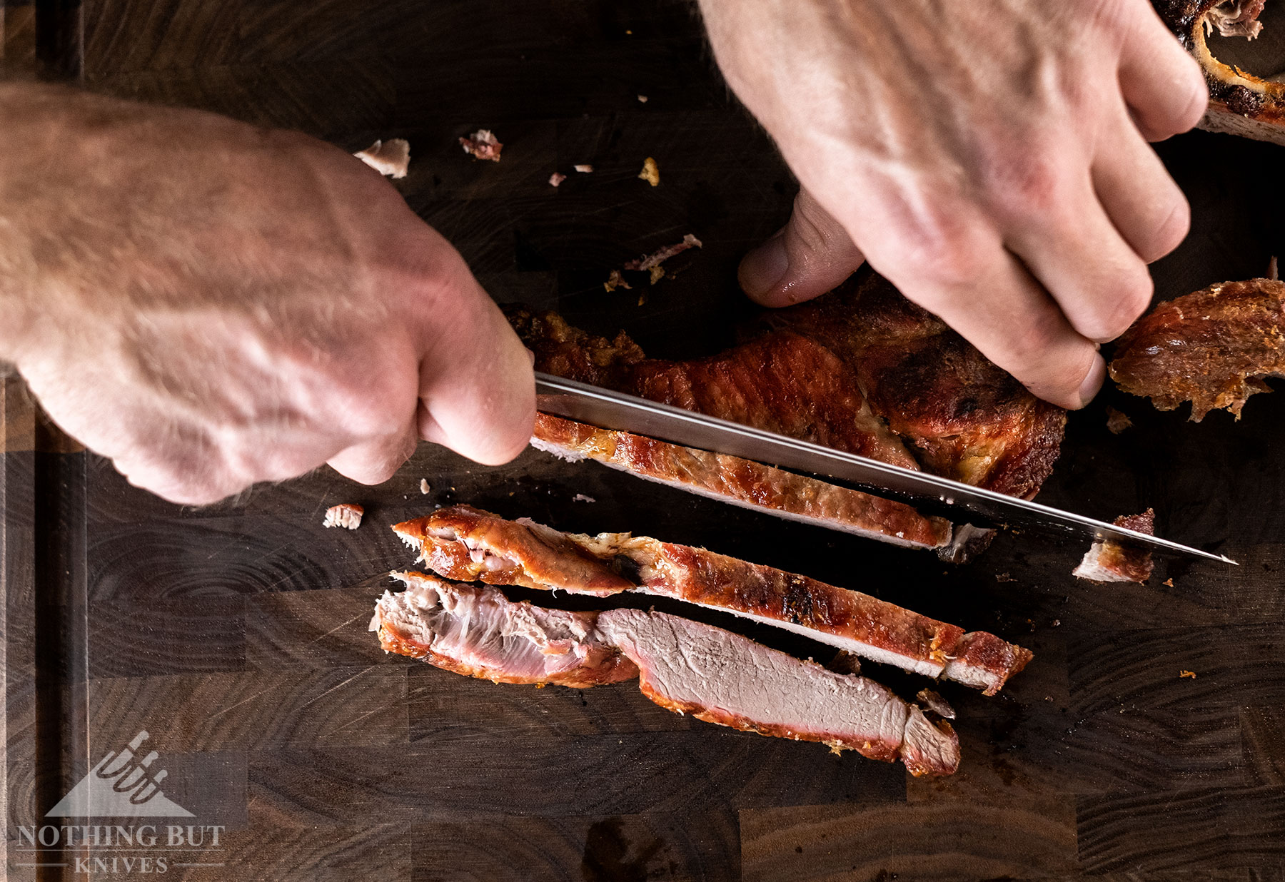 A close-up of meat being sliced with the Kramer By Zwilling Euro Essential Stainless 8 inch chef knife.