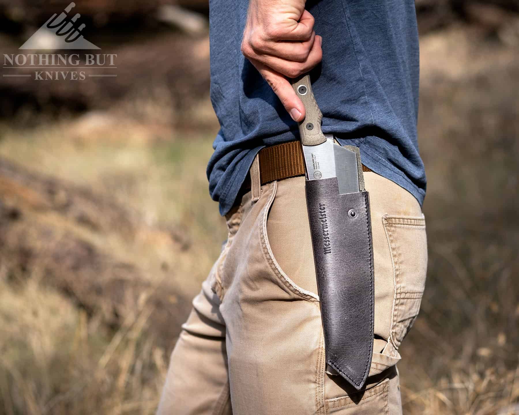 Our Search For The Best Camping Chef Knife - Image 10 The Messermeister Overland camp cooking knife shown here being deployed from its leather sheath on a person's hip.