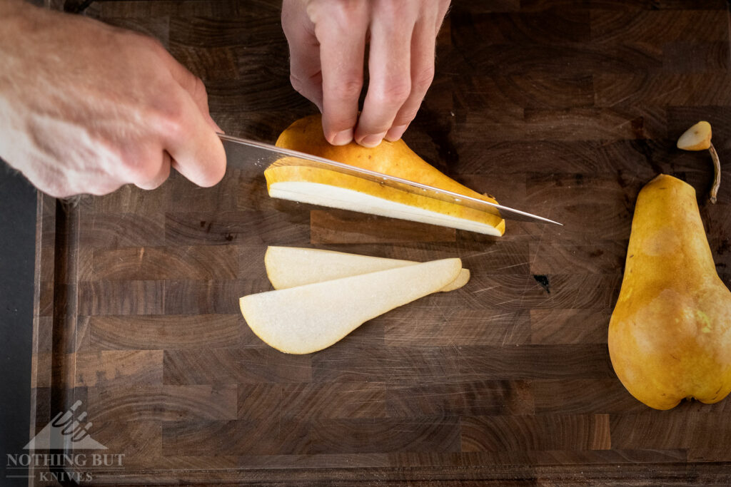 Slicing a pear with the Kramer By Zwilling Euro Stainless Essential 8 inch chef knife.