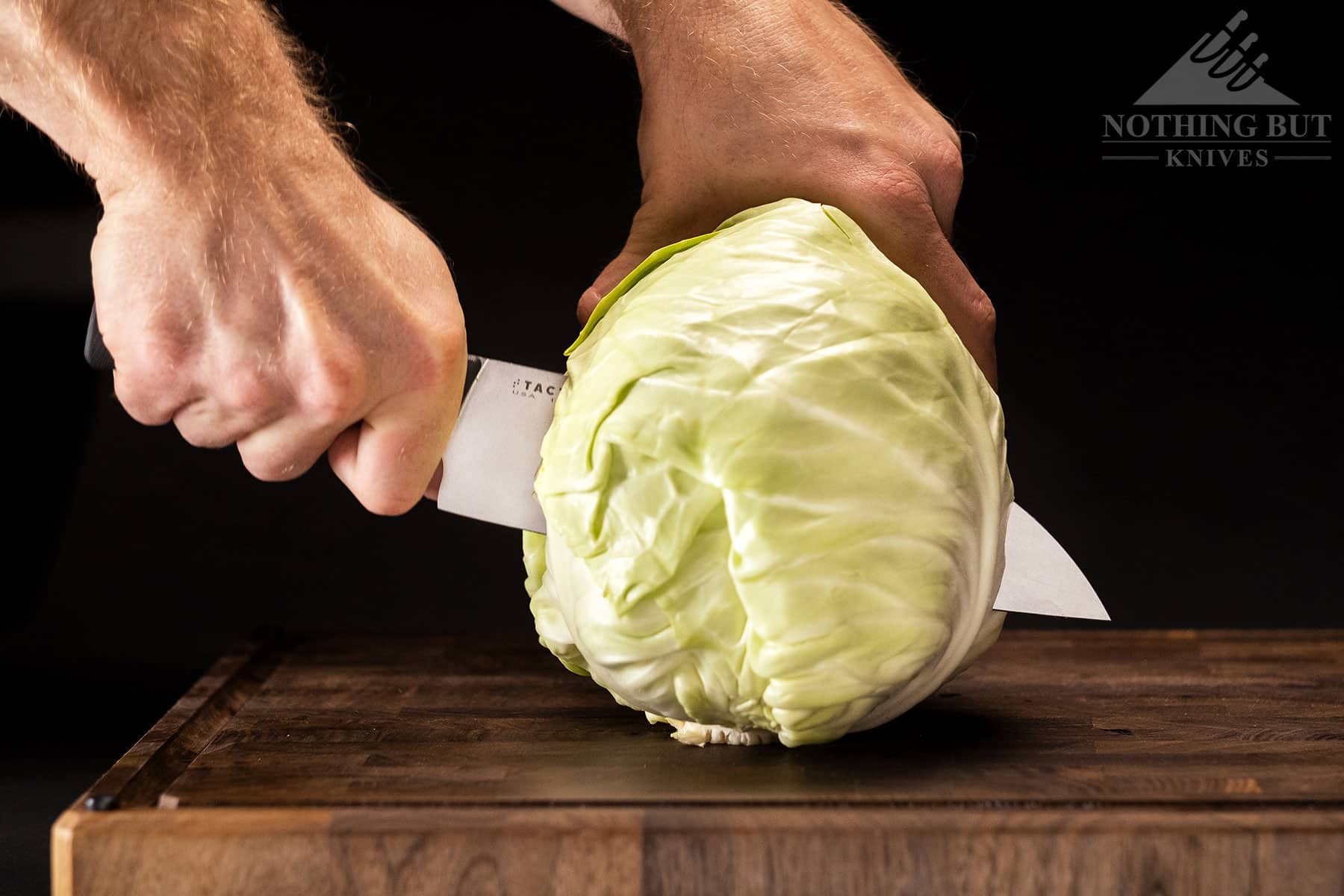 The 8 inch Tactile Santoku Knife slicing a head of cabbage in half.