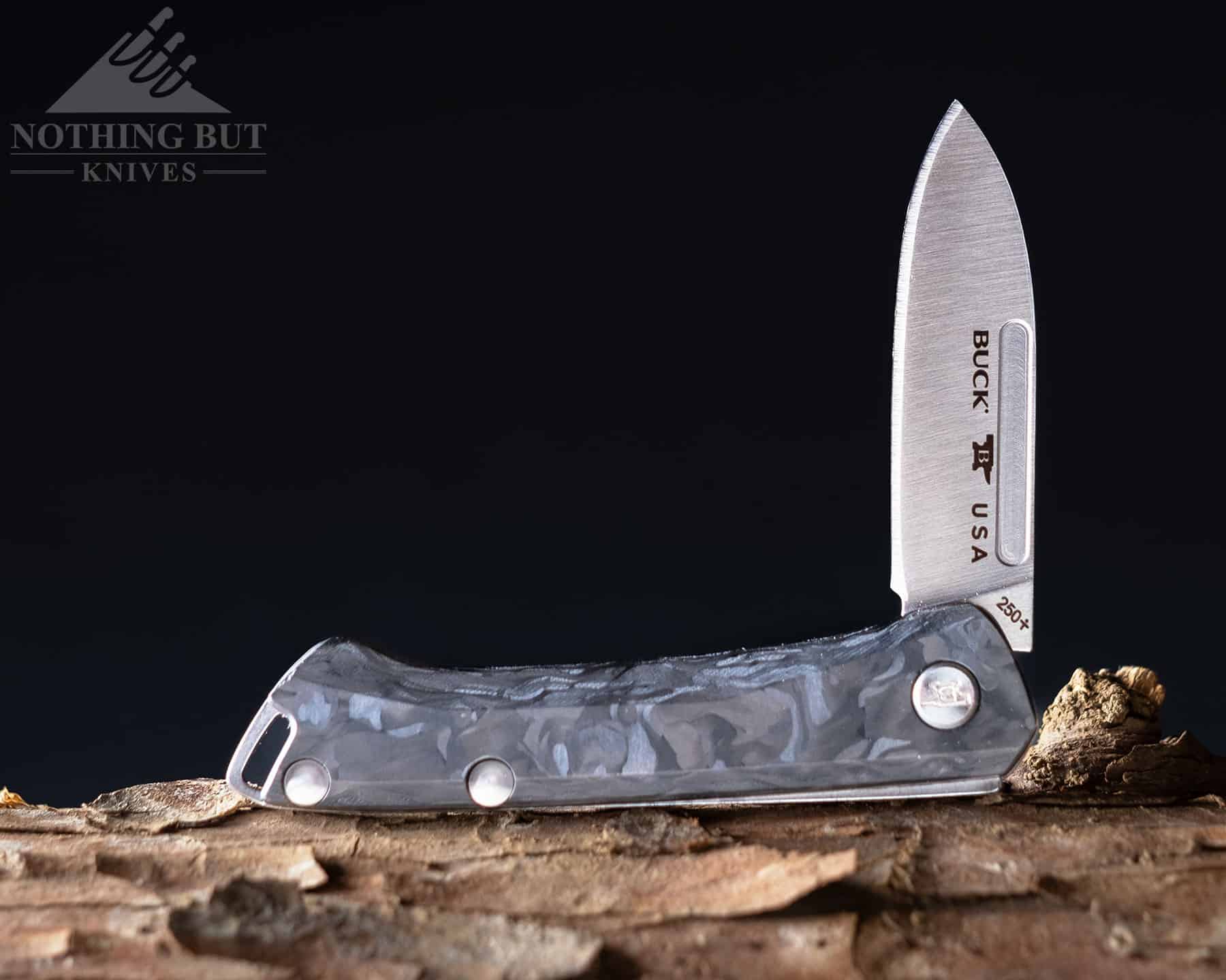 Studio image of the Buck Saunter that shows its marbled carbon fiber handle and drop point blade profile. 