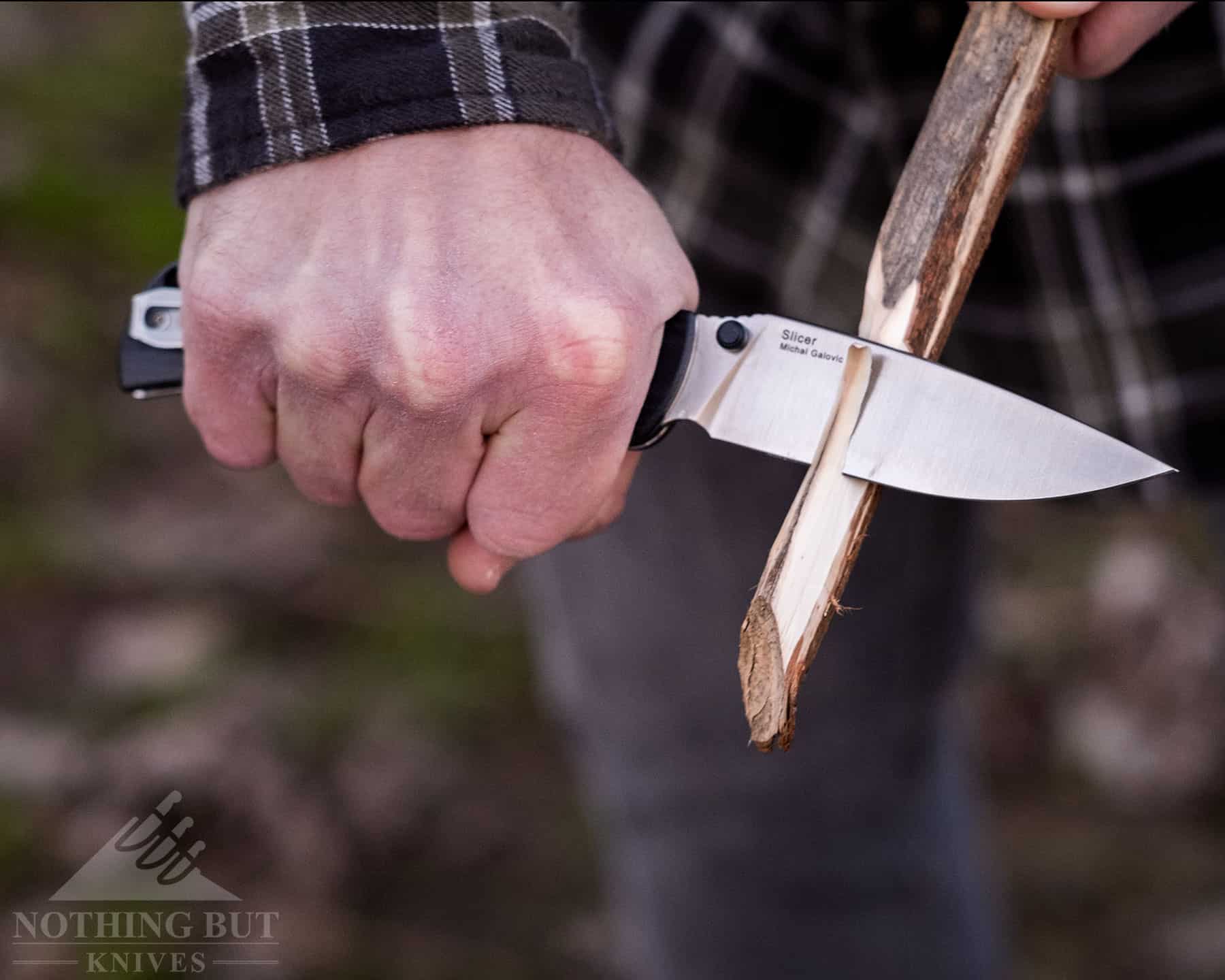 The Best Hard Use Pocket Knives Under $50 And $100 37 The Kizer Slicer effortlessly carving a hot dog roasting stick on a camping trip.