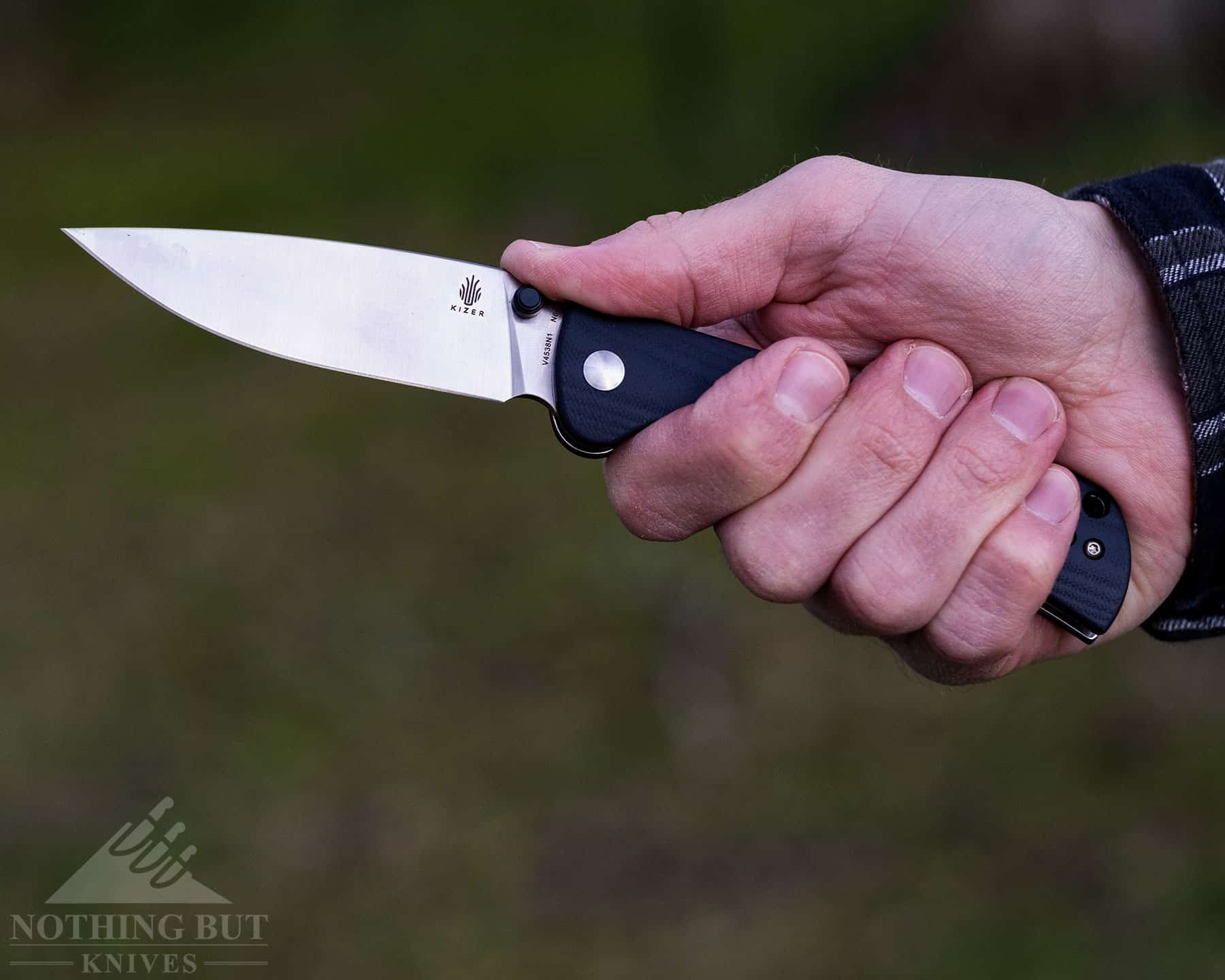 A close-up of a person's hand gripping a hard use pocket knife to show the comfort of the handle. 