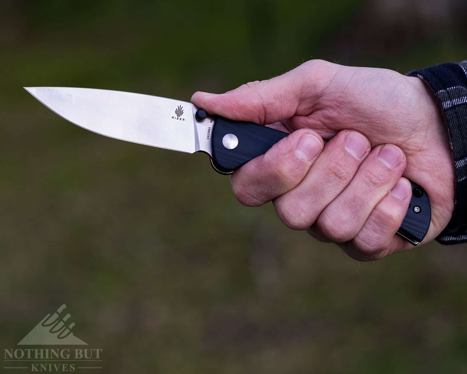 Best Hard Use Pocket Knives Under $50 And $100 - Image 58 A close-up of a person's hand gripping a hard use pocket knife to show the comfort of the handle.