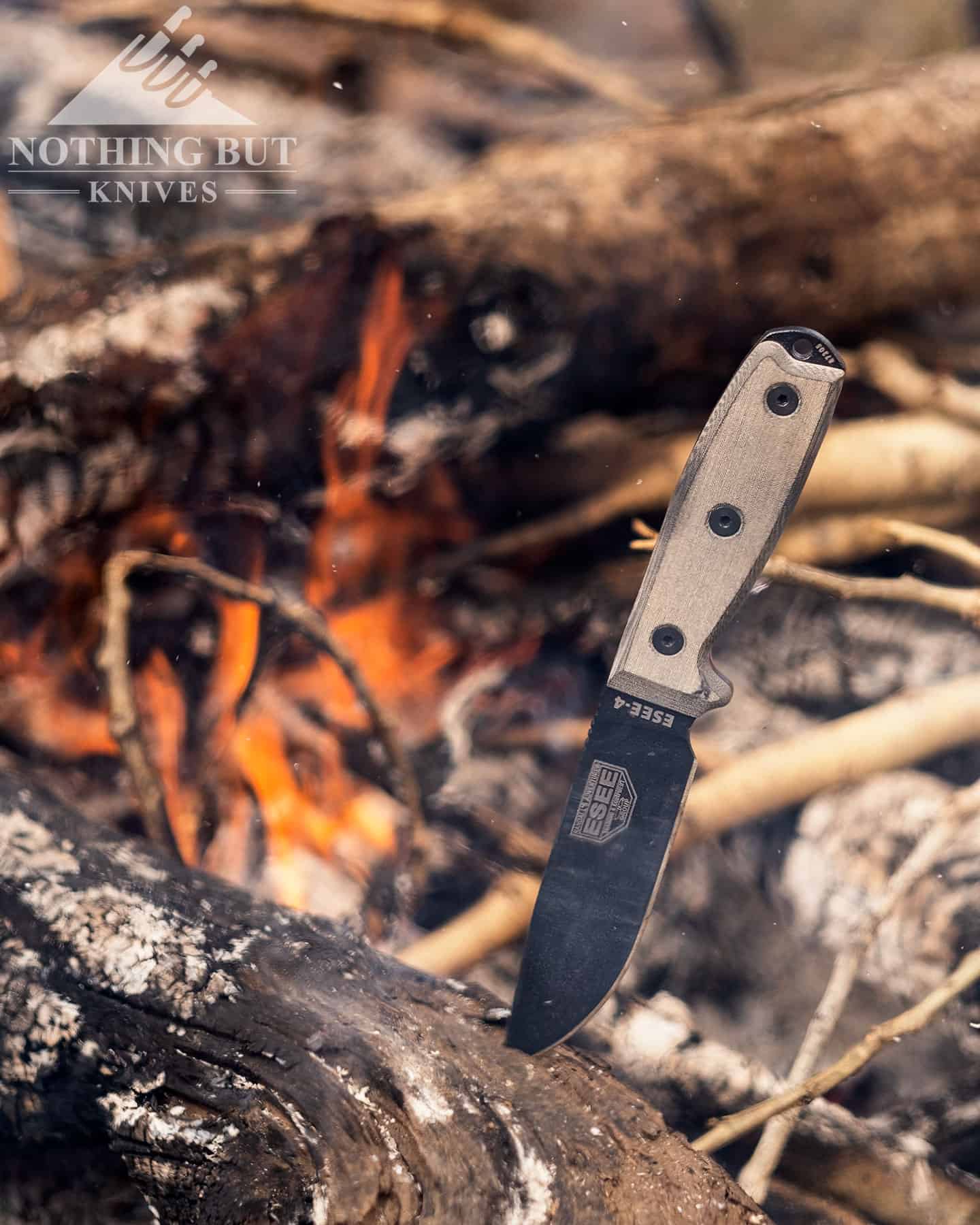 The Esee 4 next to a campfire to illustrate its ability to cover tactical and survival knife needs.
